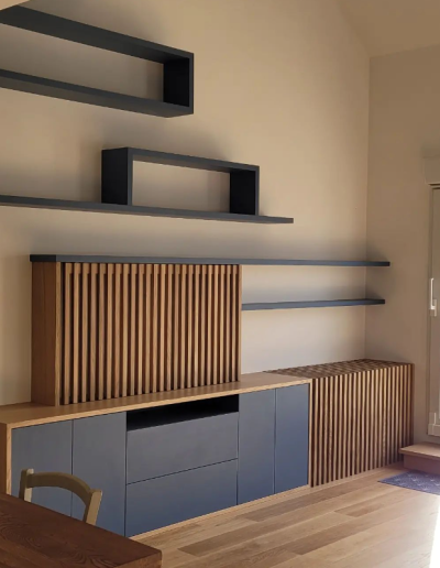Réalisation à Meaux : aménagement de salon sur mesure en chêne véritable et mélaminé bleu. Niches murales, cache radiateur en chêne massif avec abattant, meuble avec claustra coulissant pour cacher l’écran TV.
